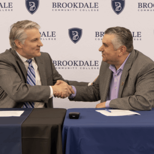 Monmouth University President shakes hands with Brookdale Community College President David M. Stout.